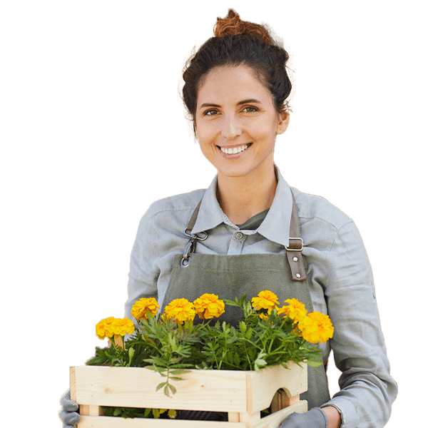 A woman holding a wooden crate with flowers in it.